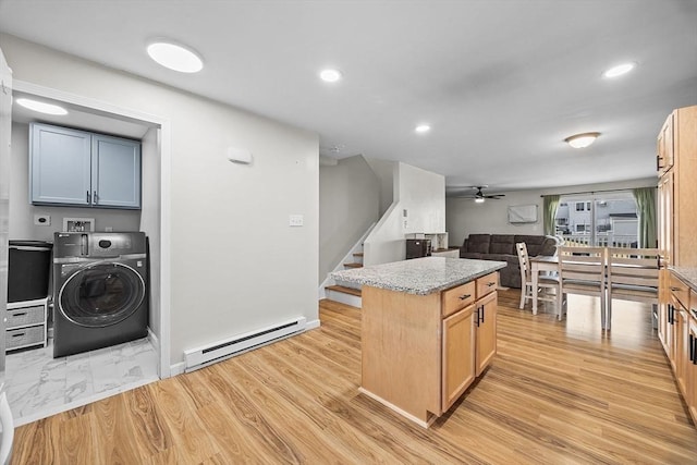 kitchen with a kitchen island, a baseboard heating unit, open floor plan, light wood-style floors, and washer / clothes dryer