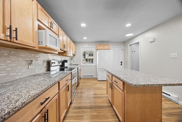 kitchen with white appliances, light stone countertops, light wood-style flooring, a sink, and baseboard heating