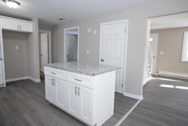 kitchen with a baseboard radiator, dark wood-type flooring, white cabinetry, light stone countertops, and baseboards