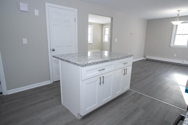 kitchen featuring dark wood-style floors, a baseboard heating unit, white cabinets, and a wealth of natural light