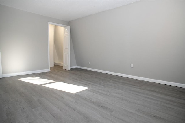 unfurnished room featuring wood finished floors and baseboards