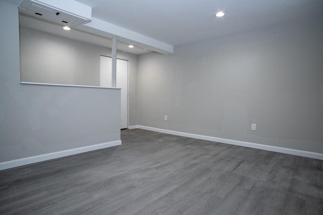 basement featuring baseboards, dark wood-type flooring, and recessed lighting