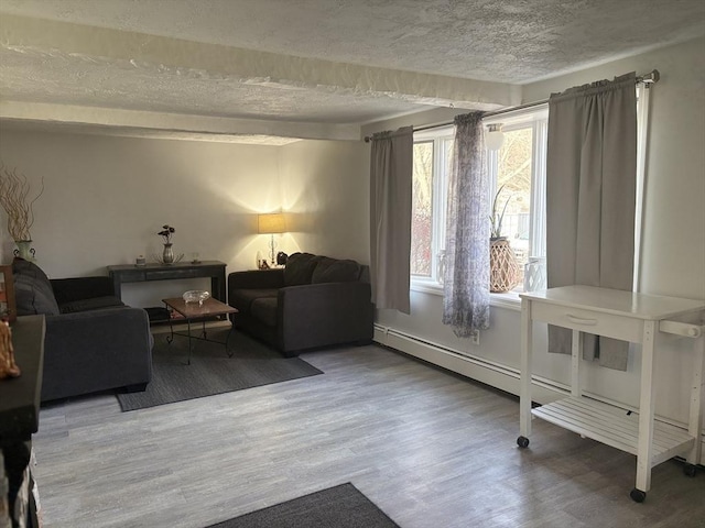 sitting room with wood-type flooring, a textured ceiling, and baseboard heating