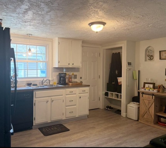 kitchen with white cabinets, light wood-type flooring, dishwasher, and sink