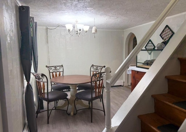 dining room with a chandelier, crown molding, light hardwood / wood-style floors, and a textured ceiling