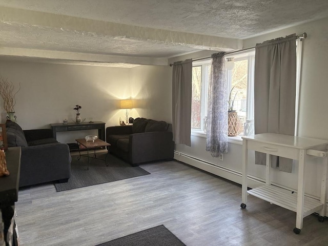 sitting room with baseboard heating, wood-type flooring, and a textured ceiling