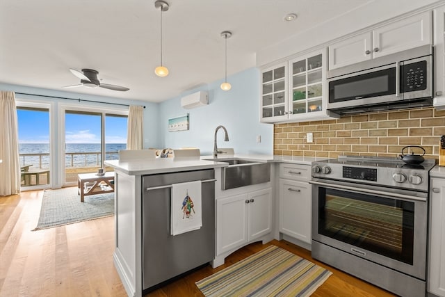 kitchen featuring white cabinetry, pendant lighting, stainless steel appliances, and kitchen peninsula