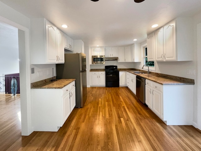 kitchen with stainless steel appliances, sink, hardwood / wood-style floors, and white cabinets