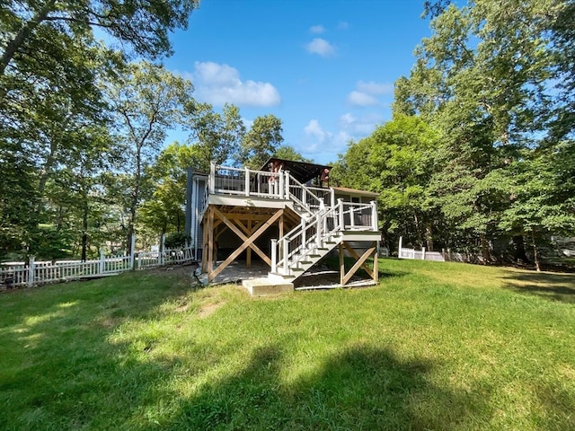 rear view of property with fence, stairway, a wooden deck, and a lawn