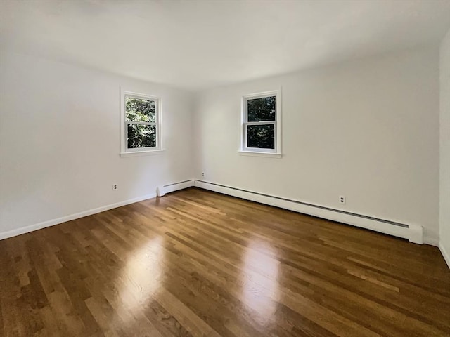 unfurnished room featuring a baseboard radiator, dark wood-style flooring, and baseboards