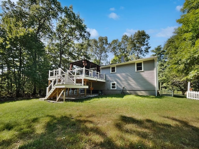 back of house featuring a deck, stairway, fence, and a lawn