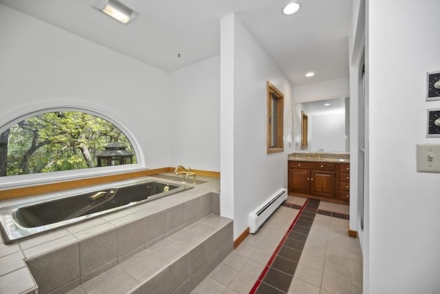 bathroom with tiled tub, tile patterned flooring, vanity, and a baseboard heating unit