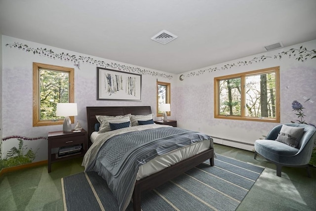 bedroom featuring multiple windows and a baseboard heating unit