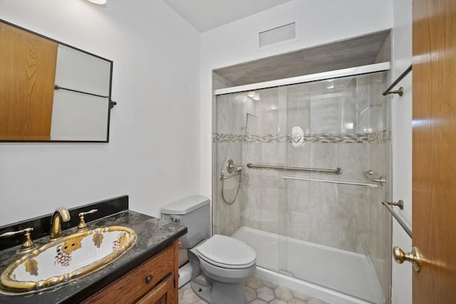 bathroom featuring tile patterned floors, vanity, toilet, and walk in shower