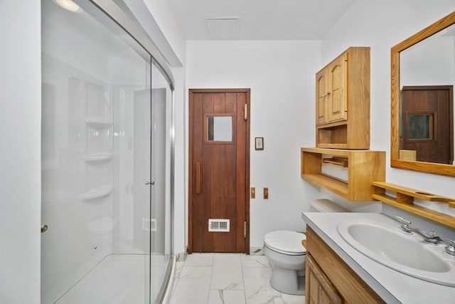 bathroom with vanity, toilet, and a shower with door