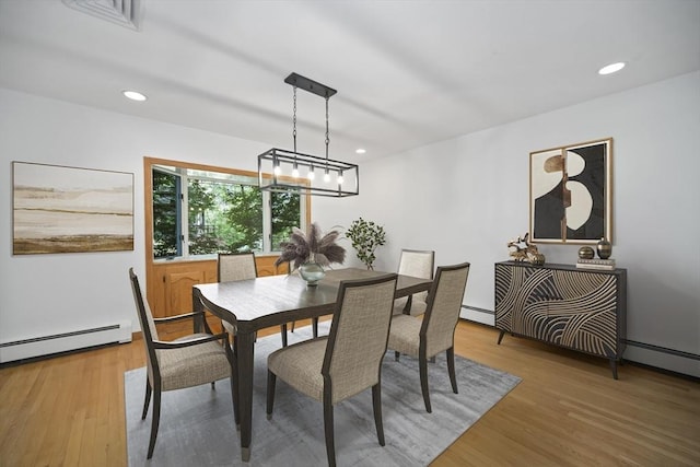 dining room with a baseboard radiator and hardwood / wood-style flooring