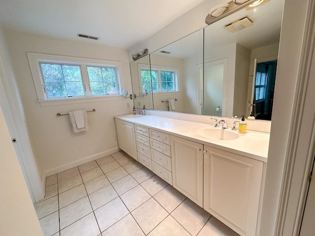full bath with tile patterned floors, visible vents, double vanity, and a sink