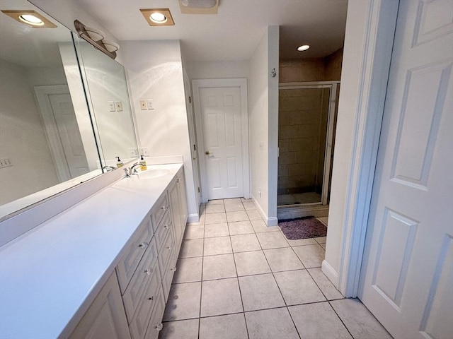 bathroom featuring vanity, a shower stall, tile patterned floors, and baseboards