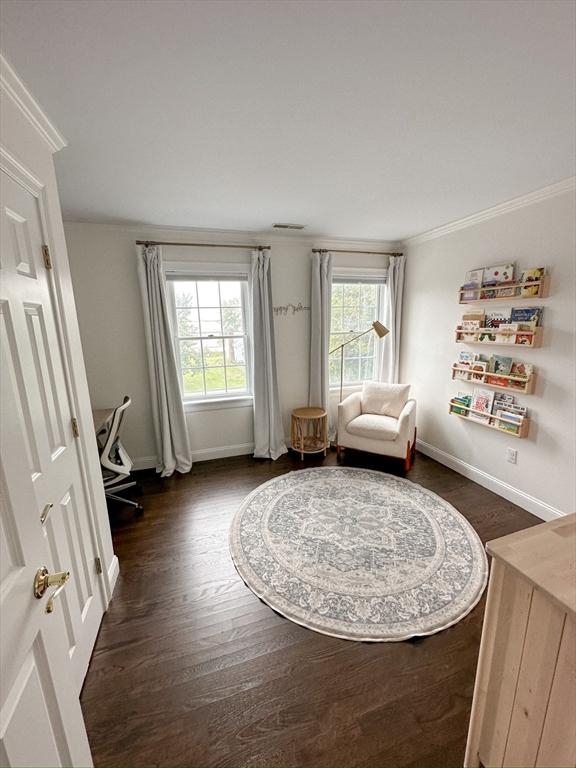 living area with dark wood-type flooring, baseboards, and plenty of natural light