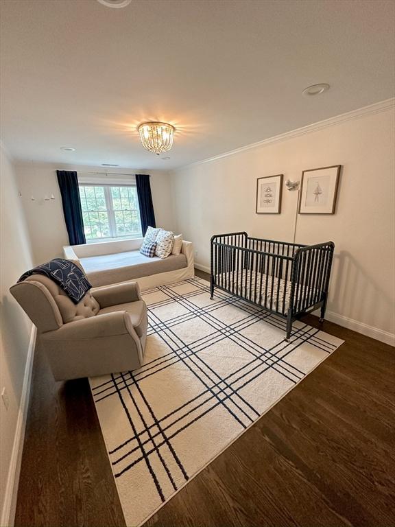 bedroom with a notable chandelier, crown molding, light wood finished floors, and baseboards