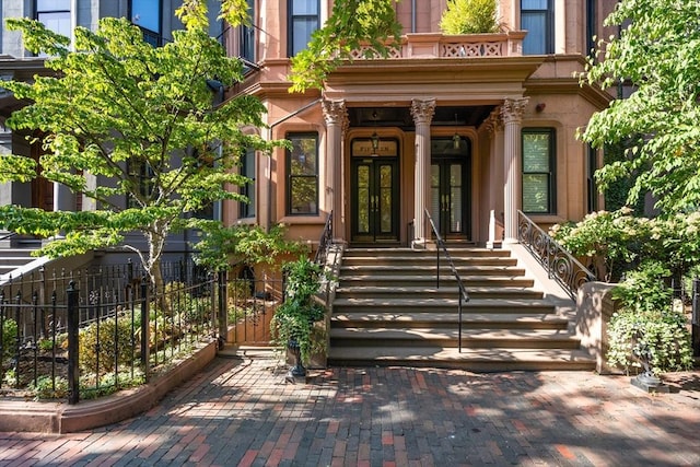 entrance to property featuring french doors and fence