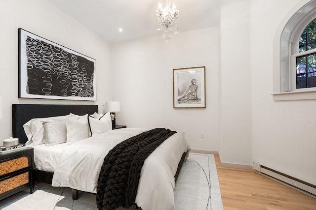 bedroom featuring a chandelier, a baseboard radiator, recessed lighting, wood finished floors, and baseboards