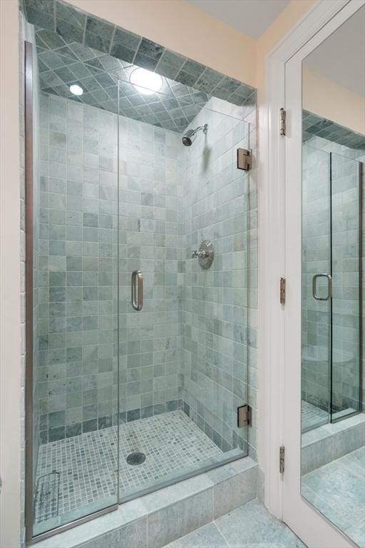 full bath featuring tile patterned flooring and a shower stall