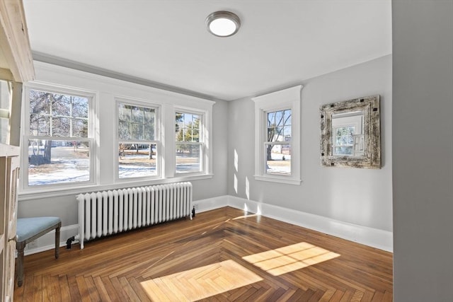 empty room featuring radiator heating unit and parquet flooring