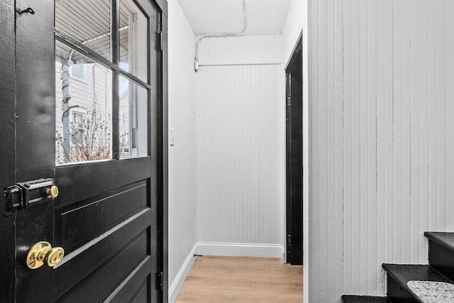 entryway featuring light hardwood / wood-style flooring and wood walls