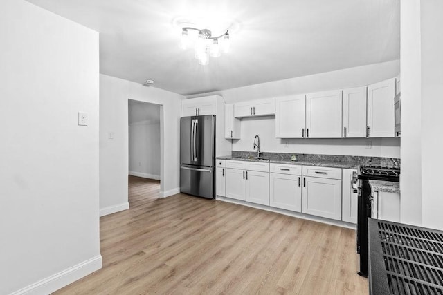 kitchen featuring appliances with stainless steel finishes, white cabinetry, and light stone counters