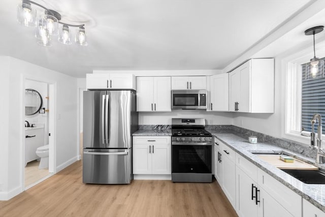 kitchen featuring white cabinetry, sink, light hardwood / wood-style flooring, and appliances with stainless steel finishes