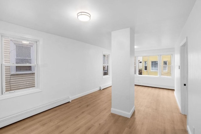 unfurnished living room featuring light hardwood / wood-style flooring and a baseboard heating unit