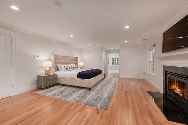 bedroom featuring recessed lighting, a fireplace with flush hearth, ornamental molding, wood finished floors, and baseboards