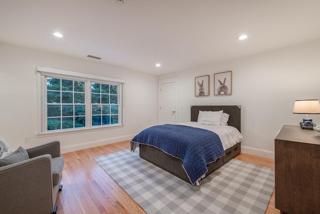 bedroom featuring light wood finished floors, baseboards, and visible vents