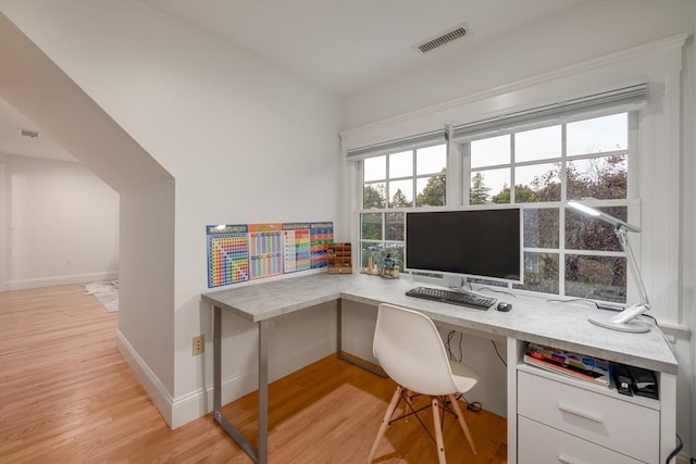 office space featuring light wood-type flooring, visible vents, and baseboards