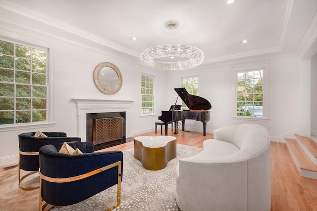 living area with a wealth of natural light, light wood-style floors, visible vents, and crown molding