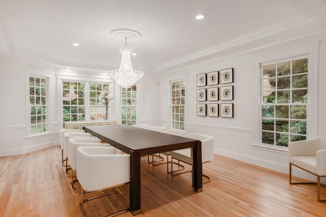 dining space featuring baseboards, light wood-style flooring, crown molding, a notable chandelier, and recessed lighting