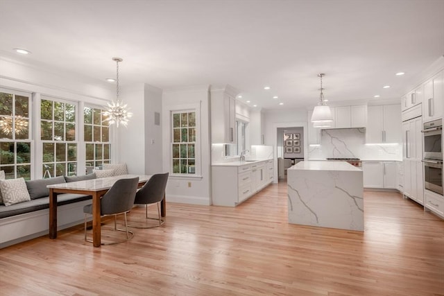 kitchen featuring breakfast area, light wood-style floors, and backsplash