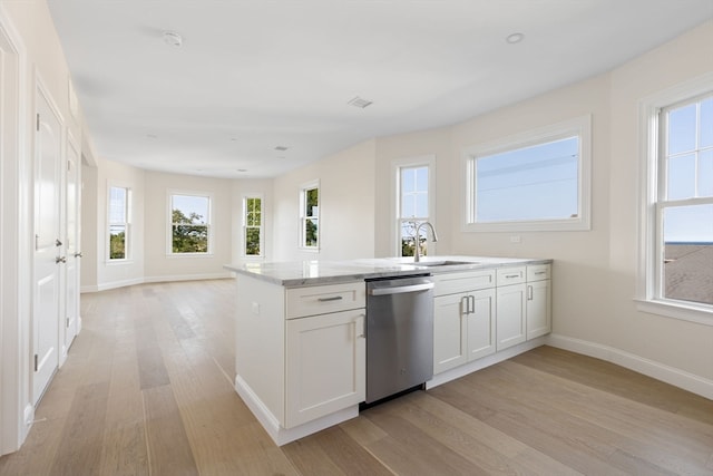 kitchen featuring dishwasher, sink, light stone counters, light hardwood / wood-style floors, and white cabinets