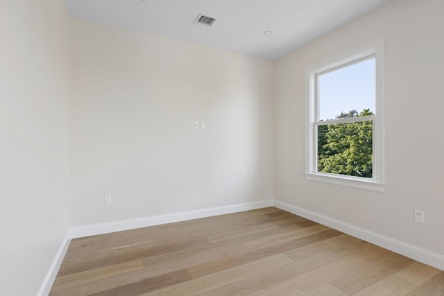 spare room featuring visible vents, baseboards, and light wood-style floors