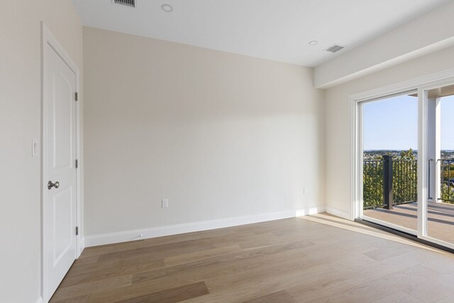 spare room featuring hardwood / wood-style floors and a wealth of natural light