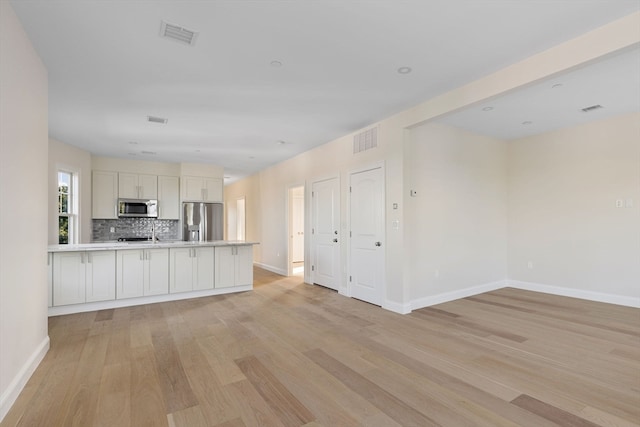 kitchen with light countertops, open floor plan, visible vents, and appliances with stainless steel finishes