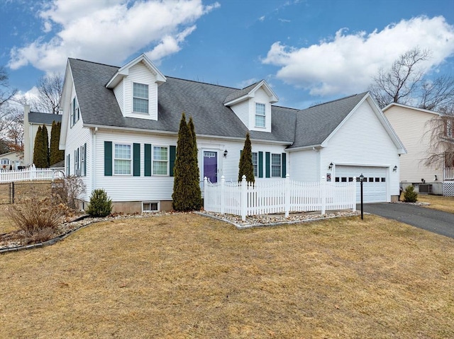 cape cod-style house with an attached garage, a shingled roof, a front lawn, fence, and driveway