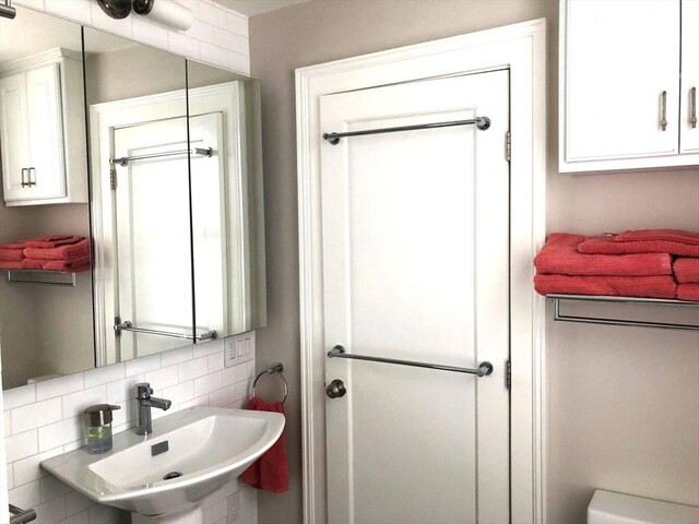 bathroom featuring a sink and tasteful backsplash