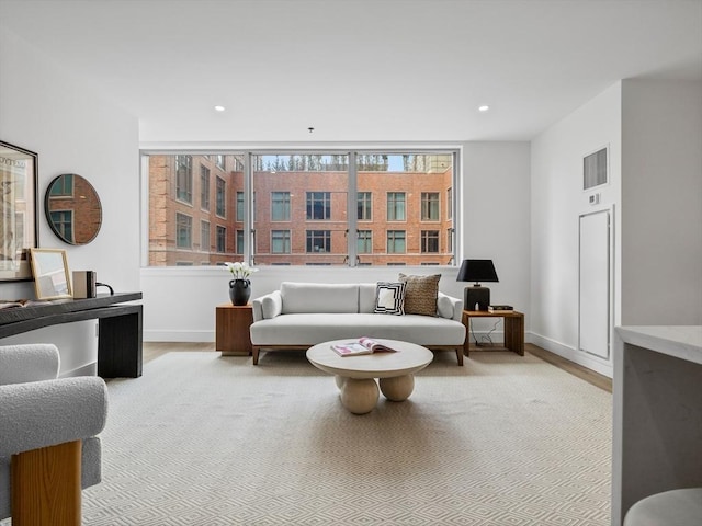 living area featuring wood finished floors, baseboards, and recessed lighting