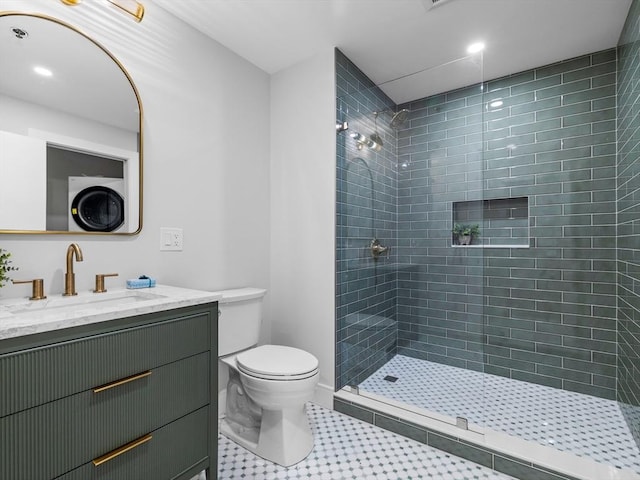 bathroom with vanity, toilet, and a tile shower