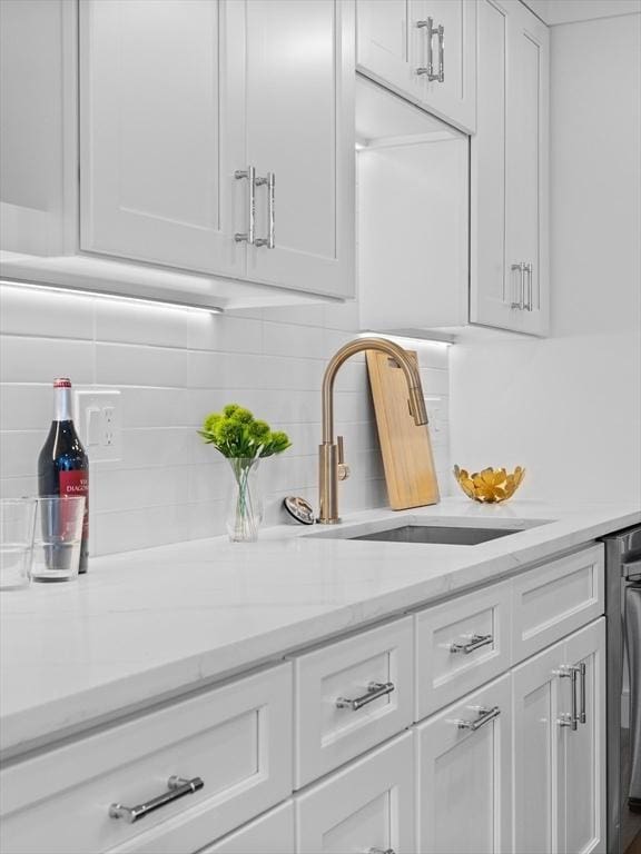 bar featuring tasteful backsplash and a sink