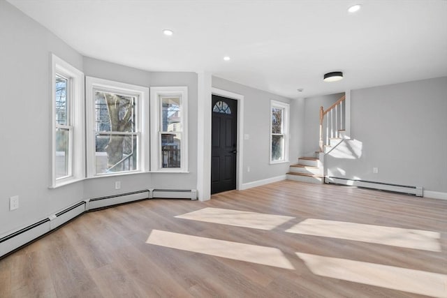 entrance foyer with baseboard heating and light hardwood / wood-style floors