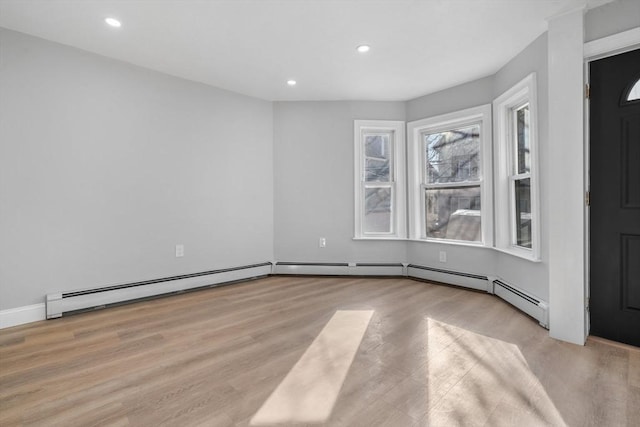 spare room featuring light hardwood / wood-style floors and a baseboard heating unit