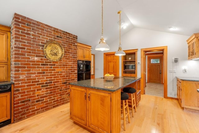 75 Haynes Rd, Sudbury, MA 01776 - kitchen with stainless steel microwave, a kitchen island, light wood-style floors, a kitchen bar, and pendant lighting